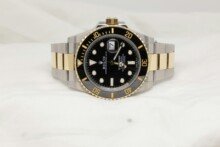 a black and gold rolex watch on a white background
