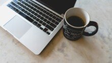 a coffee mug next to a laptop